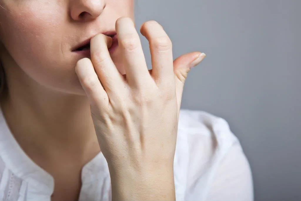 Primo piano di una persona che si mangia le unghie, segno di ansia